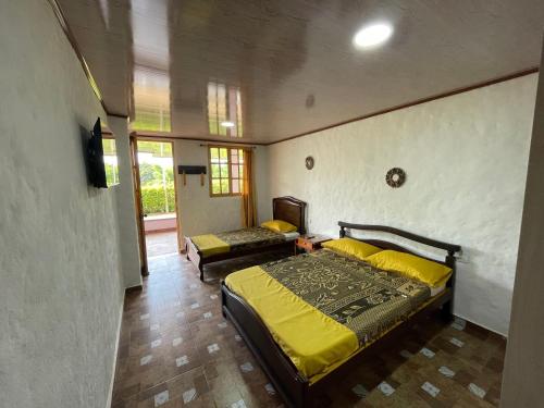 蒙特内哥罗Casa campestre Montenegro Quindio的一间卧室配有一张黄色棉被的床