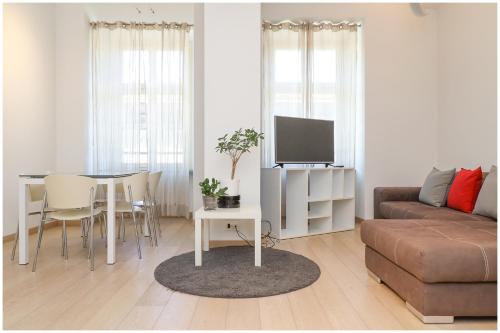 都灵Casa San Carlo nel cuore di Torino的客厅配有沙发和带电视的桌子