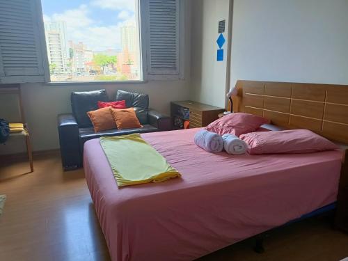 贝洛奥里藏特Apartamento Centro Belo Horizonte的一间卧室配有一张大床和一张沙发