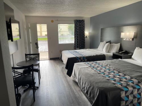 帕迪尤卡American Inn - Paducah的酒店客房设有两张床和一张桌子。