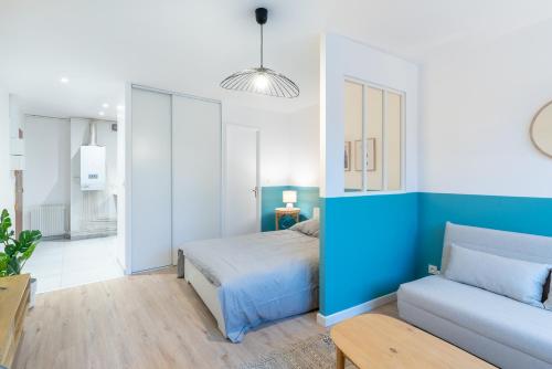 达克斯Studio centre Dax的蓝色和白色的卧室,配有床和沙发