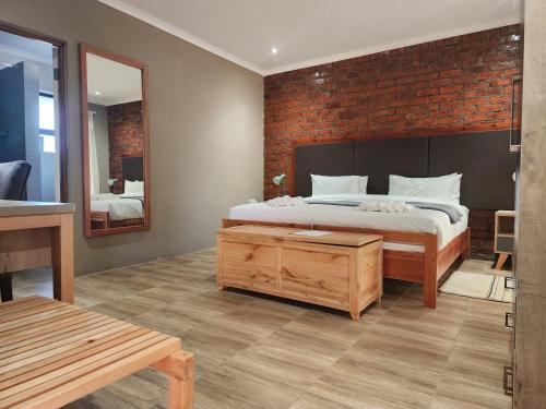MochudiMakua Bush Hotel的一间卧室设有一张床和砖墙
