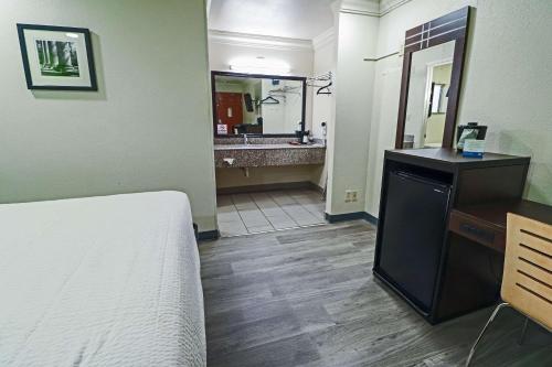 圣安东尼奥Rodeway Inn San Antonio Lackland AFB - SeaWorld的一间卧室配有一张床,浴室设有水槽