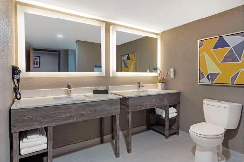 格林维尔Comfort Inn & Suites Greenville Near Convention Center的浴室设有2个水槽、卫生间和镜子。