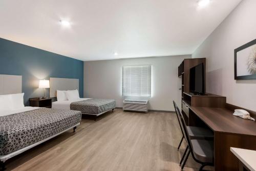 钱德勒WoodSpring Suites Chandler Airport的酒店客房设有两张床和一台平面电视。