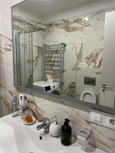 巴塞罗那La Meridian II的一间带大镜子的盥洗盆的浴室