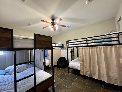 休斯顿MyCrib Houston Hostel的客房设有四张双层床和吊扇。