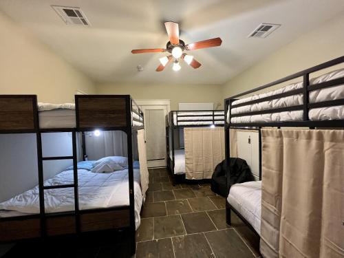 休斯顿MyCrib Houston Hostel的客房设有四张双层床和吊扇。