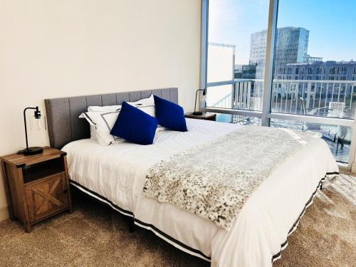 奥斯汀Downtown Oasis Heart Of Austin的一间卧室配有一张带蓝色枕头的床和一扇窗户。