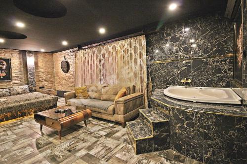 安卡拉Elegant House Otel的带沙发和浴缸的客厅