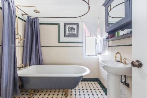 布里斯班Fernberg Cottage - Sunny Queenslander Charm的带浴缸和盥洗盆的浴室