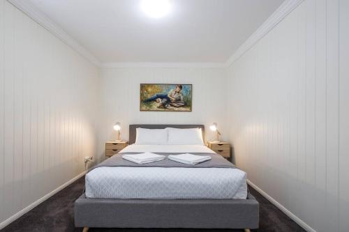 布里斯班Fernberg Cottage - Sunny Queenslander Charm的一间卧室配有一张床,上面有两本书