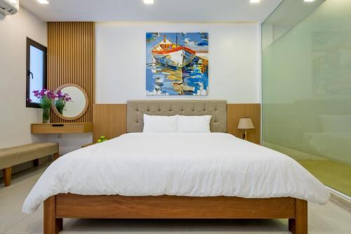 岘港Luxury Beach Villa Da Nang的卧室配有一张床,墙上挂有绘画作品