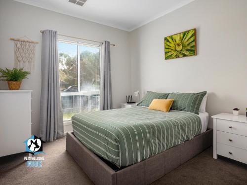 维克多港3BR Contemporary Home with Sea Views的一间卧室设有一张大床和一个窗户。