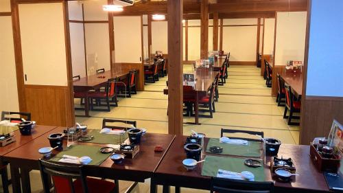 屋久岛绳文之宿蔓藤酒店的用餐室配有木桌和椅子