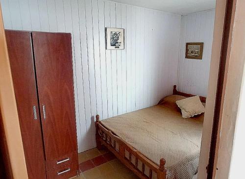 米纳斯La Casa de los Viejos的一间带床和橱柜的小卧室