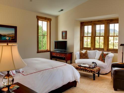 马姆莫斯湖Snowcreek Resort Vacation Rentals的一间卧室配有一张床、一张沙发和一台电视。