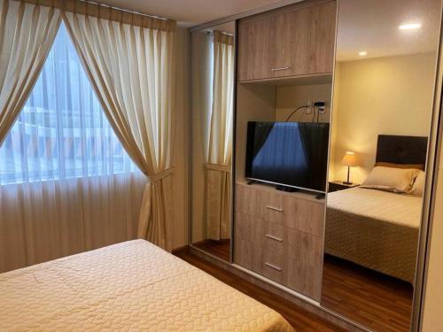 拉巴斯EL OLMO的一间卧室配有一张床和一台平面电视