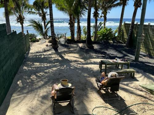 MataveraShineAwayHomes -AC Beachfront RAROTONGA的两人坐在沙滩椅上