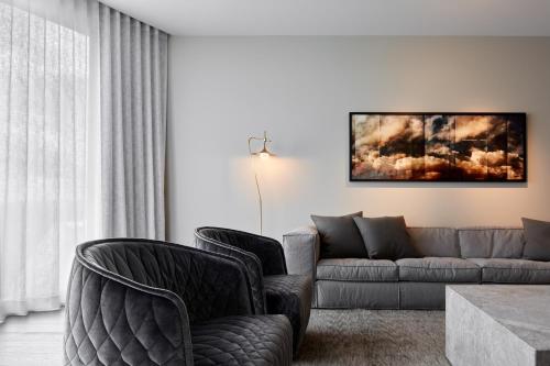 阿德莱德Eos by SkyCity的客厅配有两把椅子和一张沙发