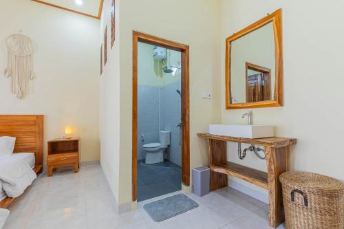 JembranaSandz House的一间带卫生间、水槽和镜子的浴室