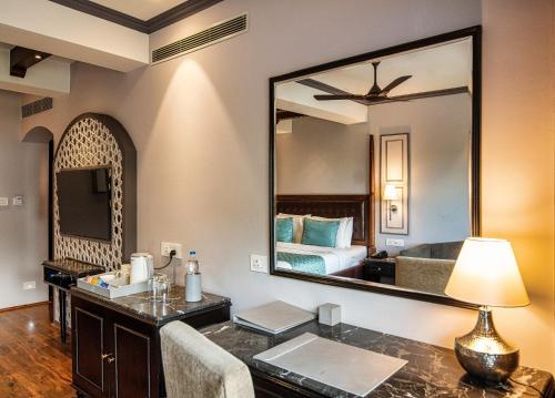 斯利那加The Vintage Srinagar at Dal Lake的一间卧室配有一张床和一个带镜子的梳妆台