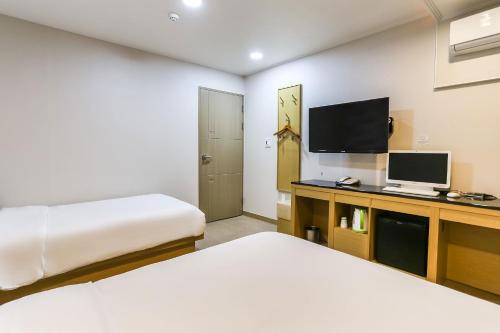 济州市Aliba Hotel的酒店客房设有两张床和电视。
