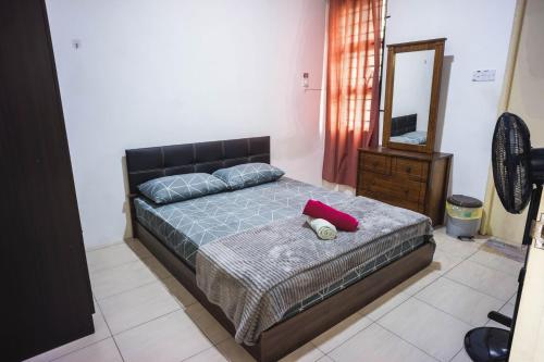 Kota SamarahanMPE Guesthouse的一间卧室配有一张带红色枕头和镜子的床
