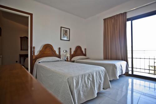 兰卡Hotel Beri的酒店客房设有两张床和一个阳台。