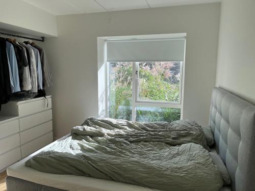奥尔堡Charming Aalborg Apartment With parking的卧室内的一张未铺好的床,设有窗户