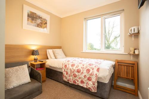 CastlepollardWhitaker Lodge Bed & Breakfast的一间卧室配有一张床、一张沙发和一个窗口