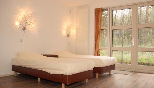 登海尔德Hotel Studio Bosch Duin Strand的配有窗户的客房内的两张床