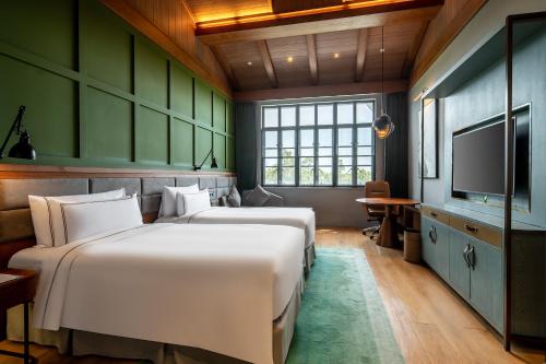 上海上海邻家美利亚酒店的配有两张床铺的绿色墙壁和电视
