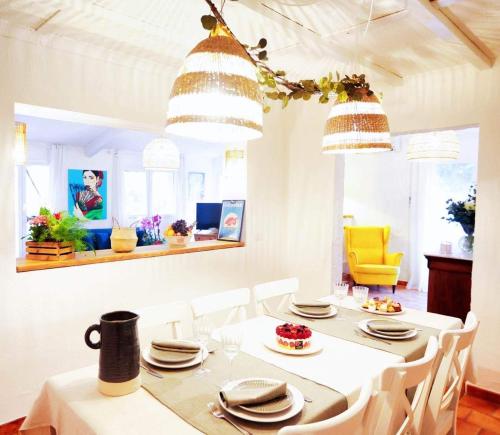莫吉奥Casa Calina的一间设有白色桌子和白色椅子的用餐室