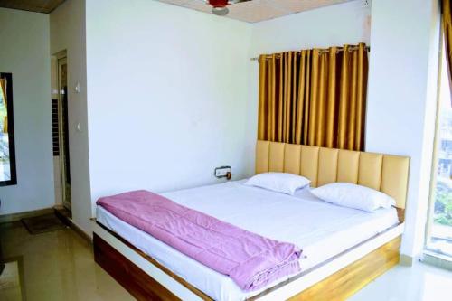 BāghdograMayer Anchal的一张位于带大窗户的房间内的床铺