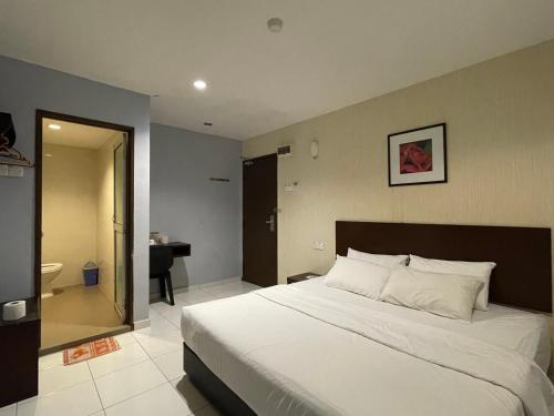 Kampong Batu TigaM Three Hotel by SECOMS的一间带白色大床的卧室和一间浴室
