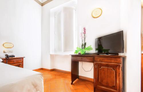 佛罗伦萨科斯坦缇尼酒店的一间带木制梳妆台的电视卧室