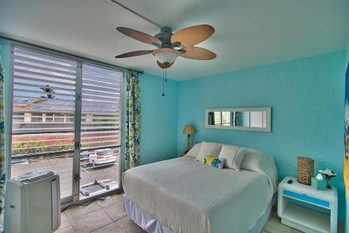 科纳Alii Villas Cozy 1BR Unit Near DT (5 Guests)的一间卧室配有一张床和吊扇