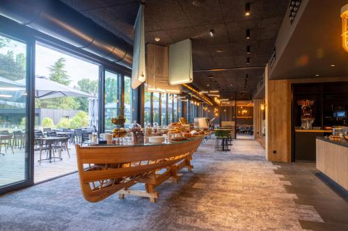 瓦戈兰斯Miura的餐厅设有长桌子、椅子和窗户