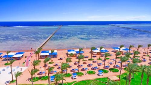沙姆沙伊赫Pickalbatros Royal Moderna Sharm "Aqua Park"的享有海滩的空中景致,配有椅子和遮阳伞
