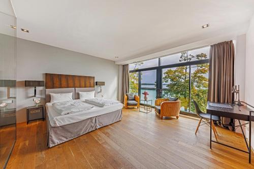 腓特烈港艾卡海滨生活酒店的卧室配有床、书桌和钢琴