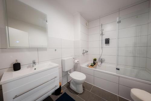 帕绍Come4Stay Passau - Apartment Seidenhof I voll ausgestattete Küche I Balkon I Badezimmer的白色的浴室设有卫生间、浴缸和水槽。