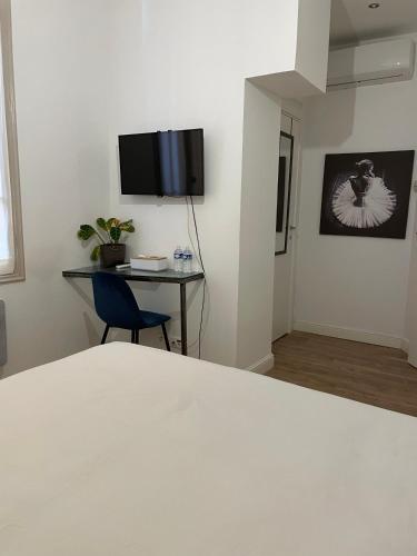 博索莱伊Chambre moderne, proche Monaco的一间卧室配有一张床和一张书桌,墙上配有电视。