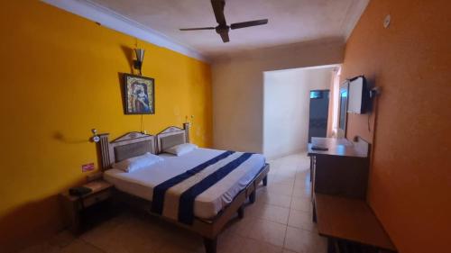 Vasco Da GamaHOTEL CITADEL的一间卧室设有一张床和黄色的墙壁