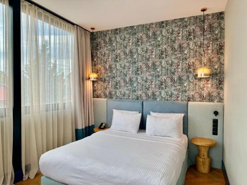 第比利斯Abanotubani Boutique hotel的一间卧室设有一张床和花卉墙