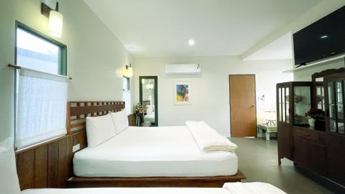 春蓬Rimsira的一间卧室设有两张床和窗户。