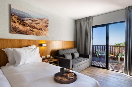 阿拉德Roxon Desert Arad的酒店客房设有床、沙发和阳台。