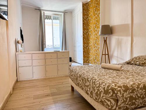 维勒班Suite Magelan的一间卧室配有一张床、一个梳妆台和一扇窗户。