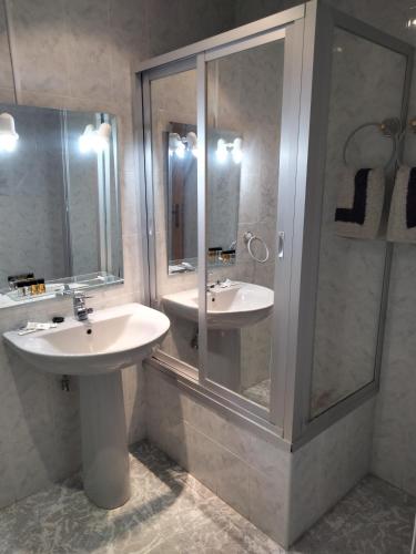 塔拉韦拉·德·拉·雷纳Hostal Restaurante El Labrador的一间带两个水槽和玻璃淋浴间的浴室