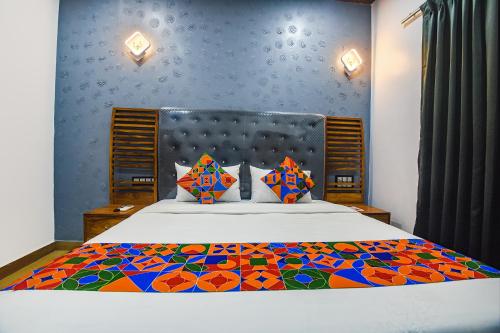 莫尔穆冈FabHotel Bay Boutique By Foxtale的一间卧室配有一张大床和色彩缤纷的被子
